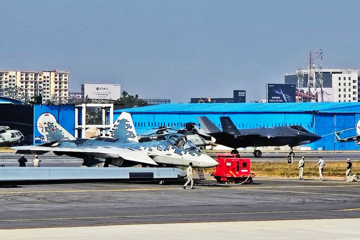 Su-57 fighter and an F-35 landing in the background